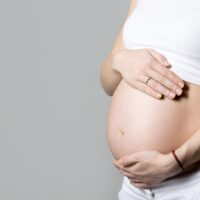 pregnant woman touching her belly